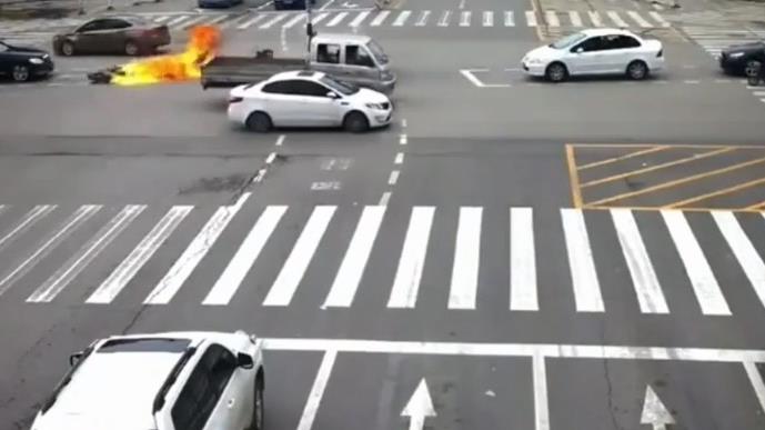 摩托车故意闯红灯，结果着火了。
