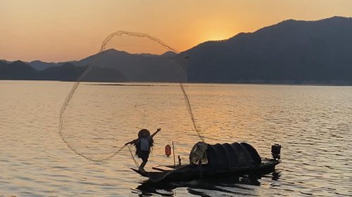 丹东绿江村的夕阳捕捉到了船只和渔网的漂移。
